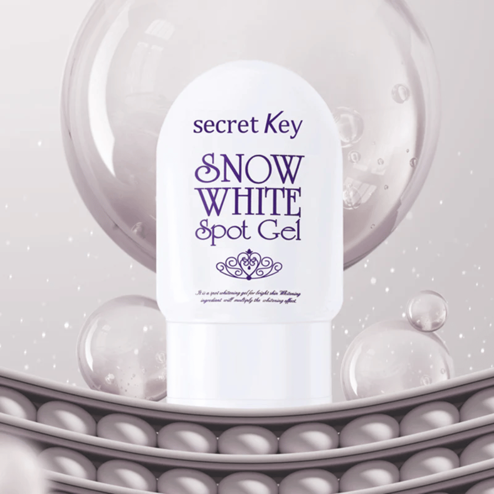 Secret Key Snow White Spot Gel v bielom obale na pozadí s bublinami a perlovými detailmi.