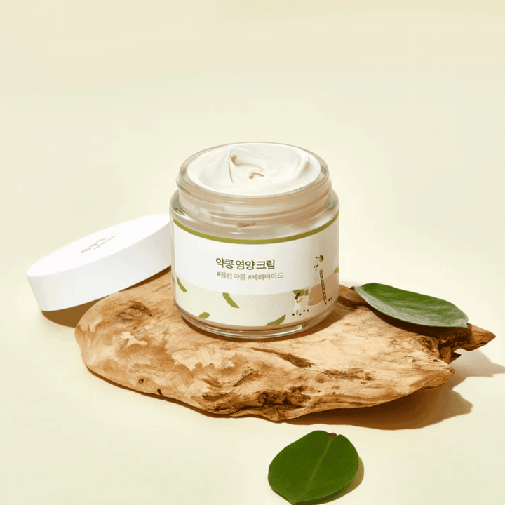 Mixsoon Soybean Nourishing Cream v otvorenej nádobe na drevenom kúsku so zelenými listami. Výživný krém s fermentovanými sójovými bôbmi a ceramidmi.