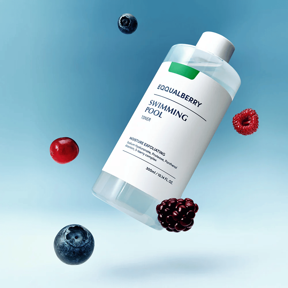 Equalberry Swimming Pool Toner v elegantnej fľaši vznášajúcej sa na modrom pozadí, obklopený čerstvým ovocím ako čučoriedky, maliny a černice.
