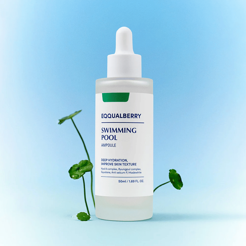 Fľaša s Eqqualberry Swimming Pool Ampoule, produkt starostlivosti o pleť na hlbokú hydratáciu a zlepšenie štruktúry pokožky, umiestnená na svetlomodrom pozadí s niekoľkými zelenými rastlinami v popredí.