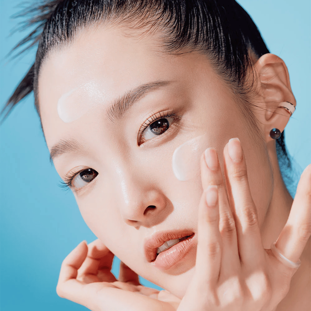 Žena pózuje s rukami na tvári v kampani na prírodnú starostlivosť o pleť TOCOBO Bio Watery Sun Cream SPF50+ PA++++ 50ml.