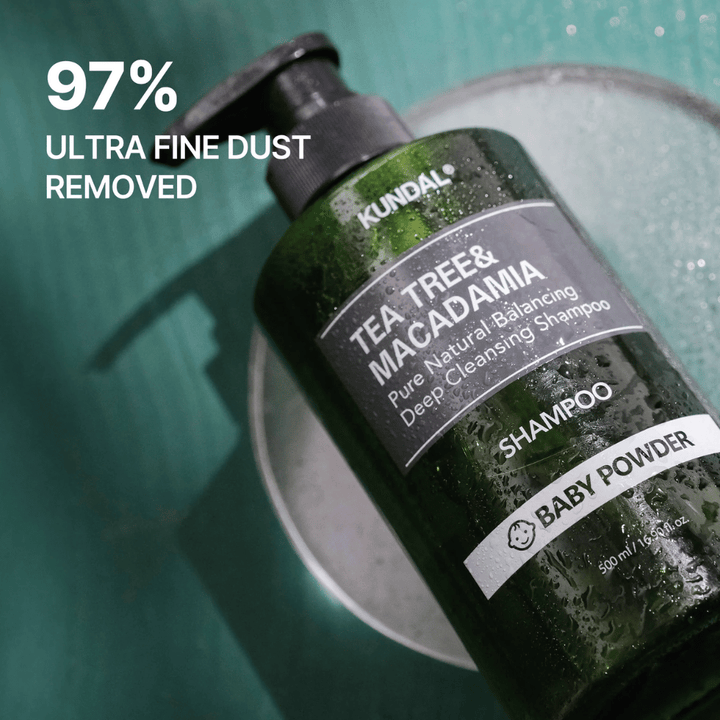 Detailný záber na KUNDAL Tea Tree & Macadamia Shampoo so zameraním na hĺbkovo čistiace vlastnosti a na to, že produkt pomáha odstraňovať ultrajemné častice a nečistoty.