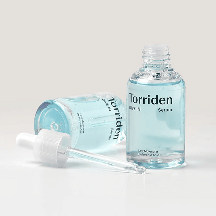 Fľaša Torriden DIVE-IN Low Molecule Hyaluronic Acid Serum 50ml vedľa fľaše vody, ktorá zdôrazňuje hyalurónové sérum a hydratáciu.