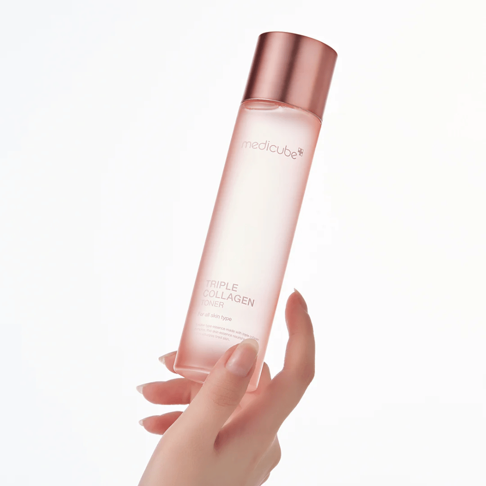 Ruka držiaca ružovú fľašu Medicube Triple Collagen Toner 4.0, hydratačný a spevňujúci toner pre všetky typy pleti.