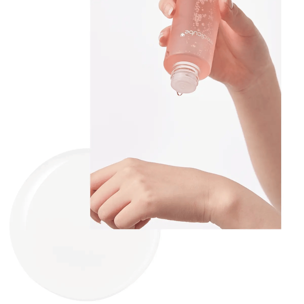 Ruka nanášajúca Medicube Triple Collagen Toner 4.0 z ružovej fľaše na pokožku, ukazuje hydratačnú konzistenciu.