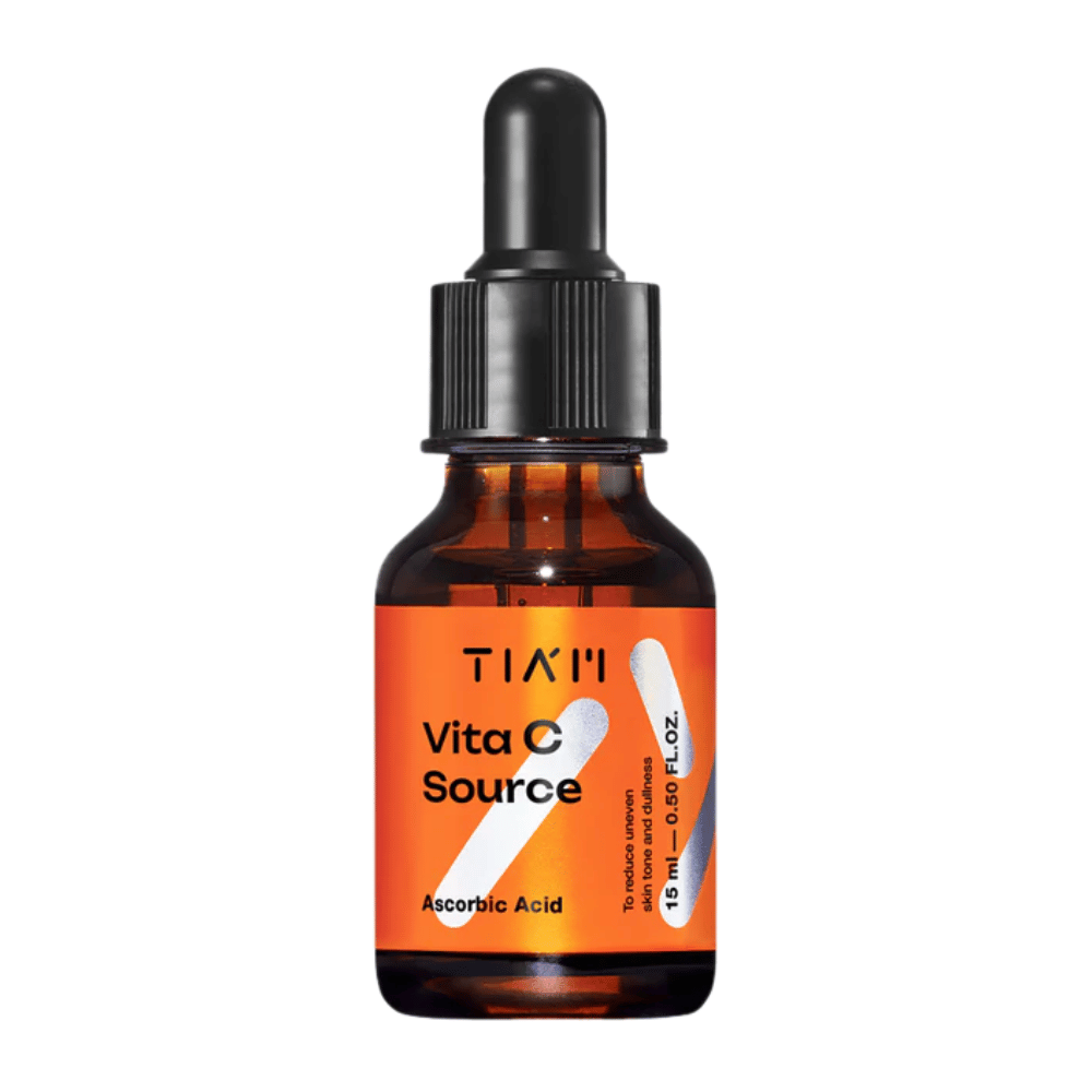 TIA'M Vita C Source, sérum s kyselinou askorbovou v hnedej sklenenej fľaši s čiernou pipetou a oranžovou etiketou – účinné na rozjasnenie pokožky a zníženie nerovnomerného tónu pleti.
