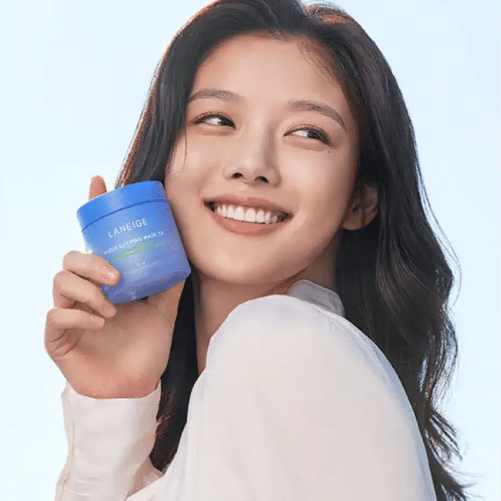 Usmievajúca sa žena drží modrú nádobu LANEIGE Water Sleeping Mask pred svetlomodrým pozadím.