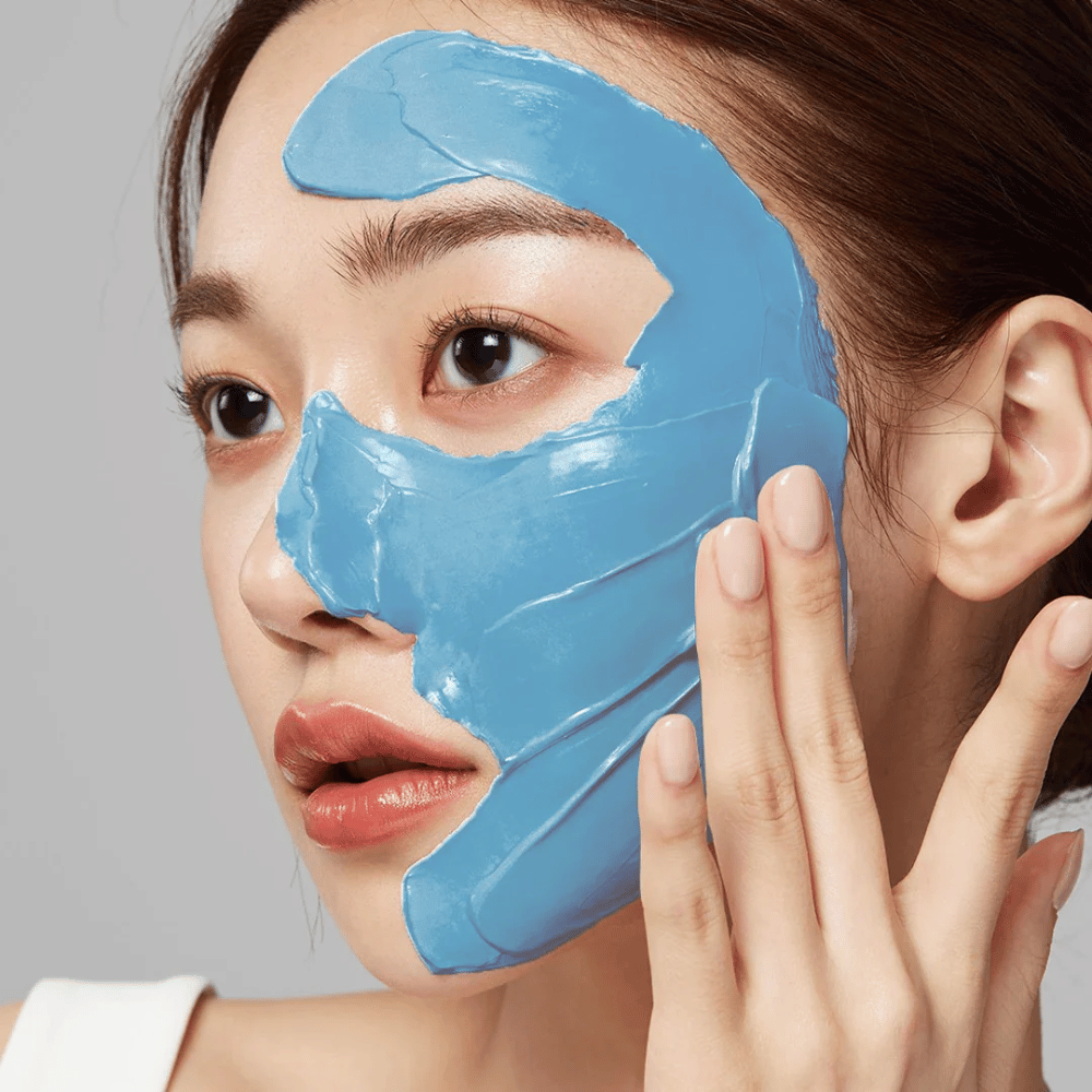 Model s modrou pleťovou maskou od Medicube, pokrýva T-zónu pre starostlivosť o póry.
