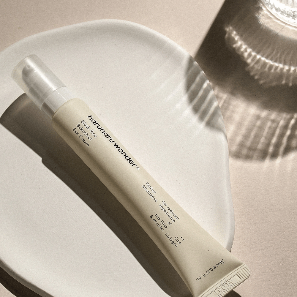HaruHaru Wonder Black Rice Bakuchiol Eye Cream 20 ml – očný krém s čiernou ryžou, bakuchiolom a kolagénom, ktorý znižuje jemné linky a vrásky, umiestnený na keramickej miske v jemnom svetle.