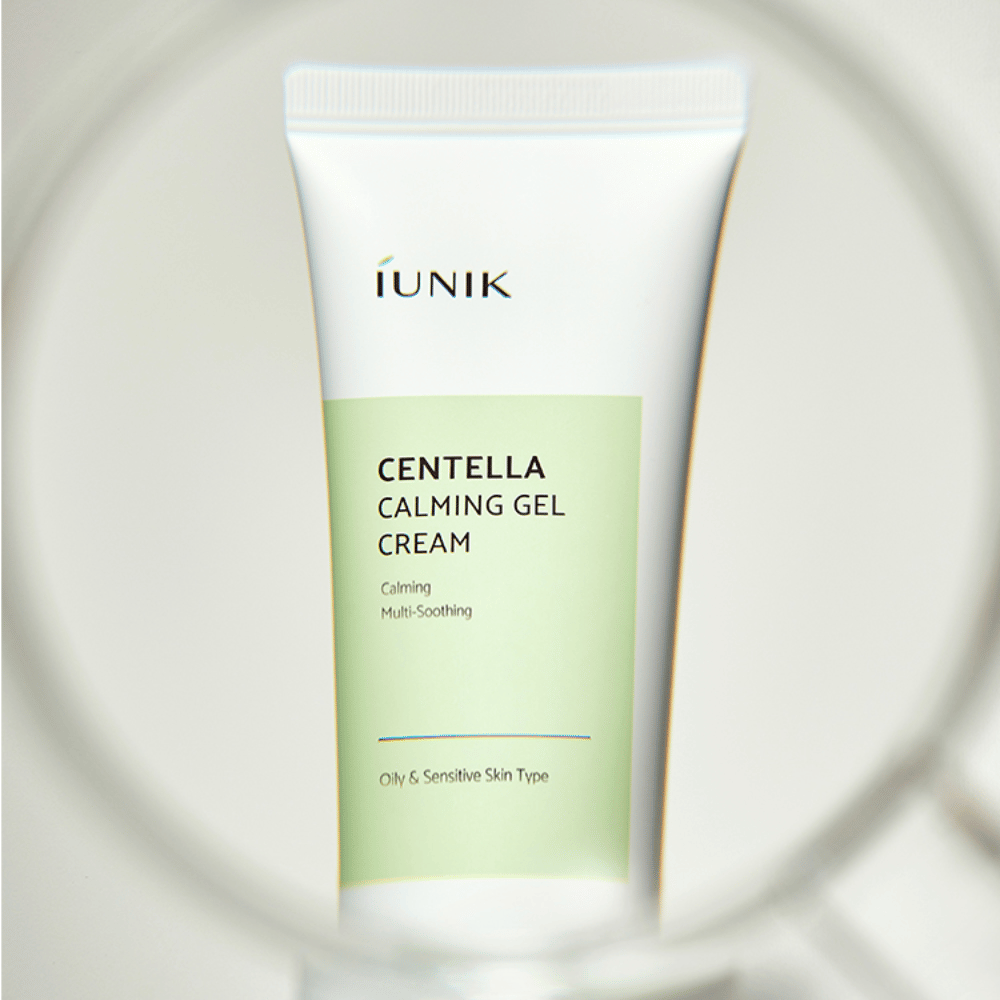 Tuba iUNIK Centella Calming Gel Cream s bielym a svetlozeleným dizajnom stojí vzpriamene, videná cez okrúhly rám podobný lupene.