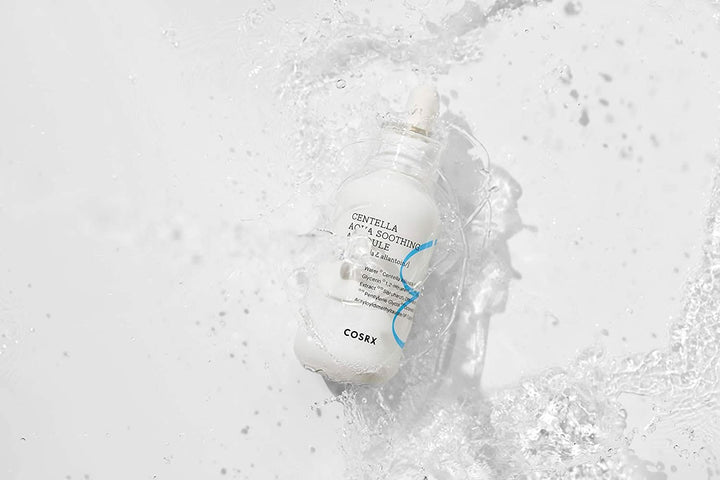 Fľaša COSRX Centella Aqua Soothing Ampoule 40ml, ktorá strieka na biely povrch, znižuje začervenanie a poskytuje upokojujúcu hydratáciu.