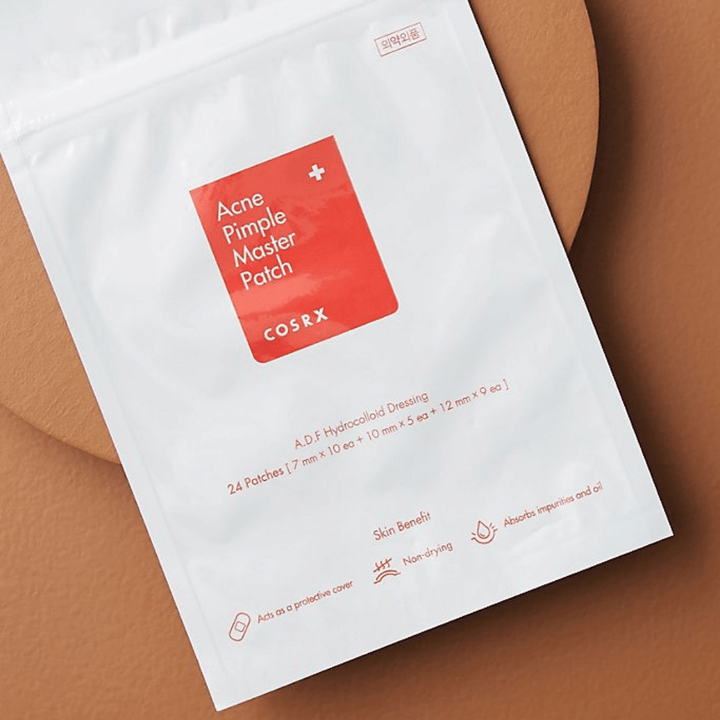 Balíček COSRX Acne Pimple Master Patch (1 balenie x 24 náplastí) na hnedom pozadí, s hydrokoloidnou technológiou na liečbu akné a pupienkov.