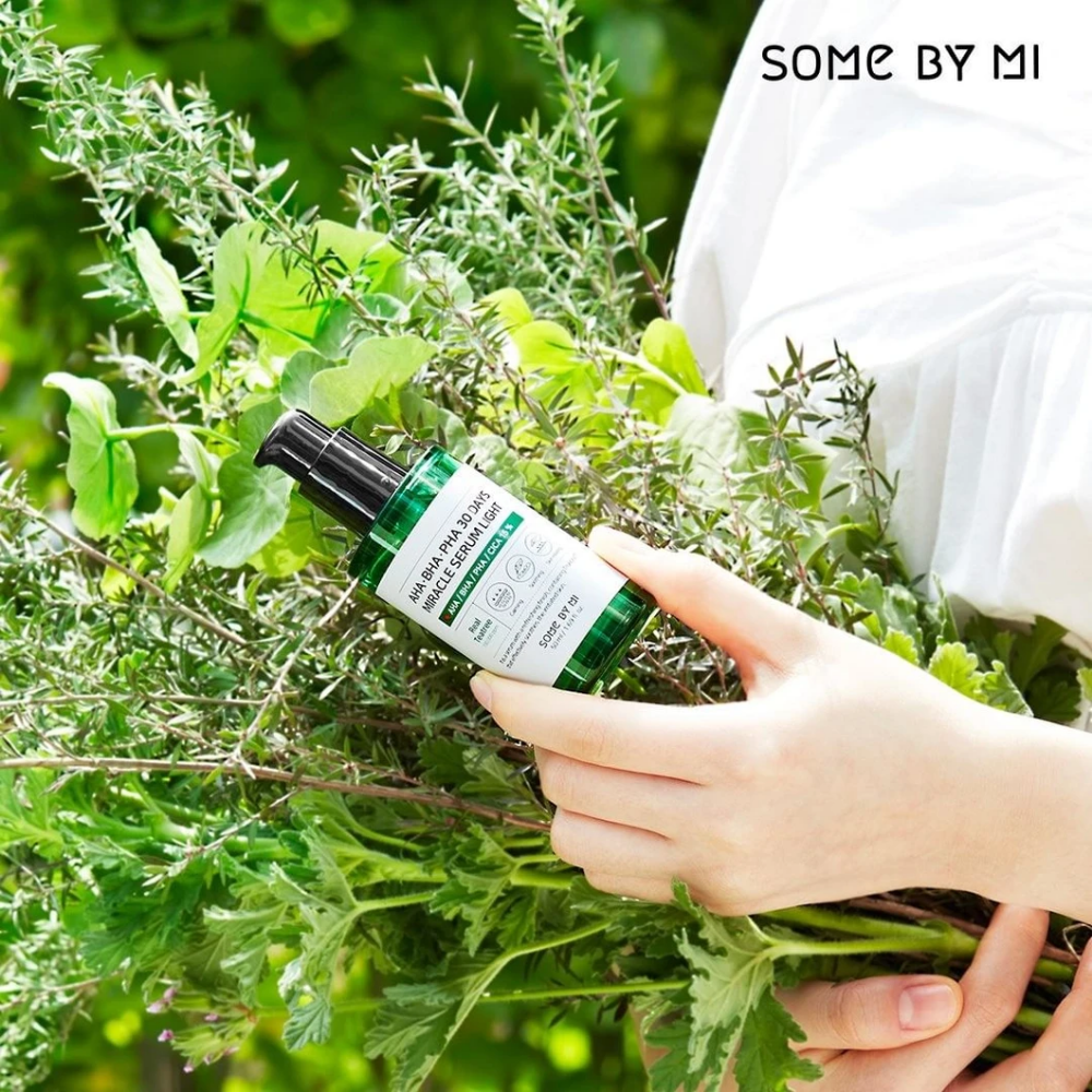 Žena, ktorá drží zväzok bylín v rukách, aby bojovala proti pigmentovým škvrnám a akné pomocou AHA, BHA, PHA 30 Days Miracle Serum Light 50ml od SOME BY MI.