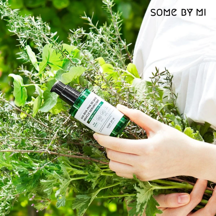 Žena, ktorá drží zväzok bylín v rukách, aby bojovala proti pigmentovým škvrnám a akné pomocou AHA, BHA, PHA 30 Days Miracle Serum Light 50ml od SOME BY MI.