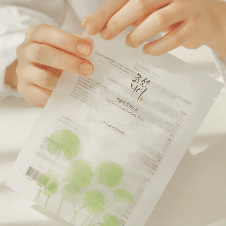 Osoba, ktorá drží papierový hárok s Beauty of Joseon Centella Asiatica Calming Mask 1 ks na ňom.