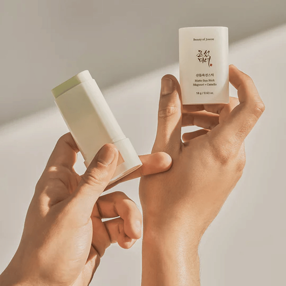 Dve ruky držiace tyčinku Beauty of Joseon's Matte Sun Stick 18g SPF50 PA++++.