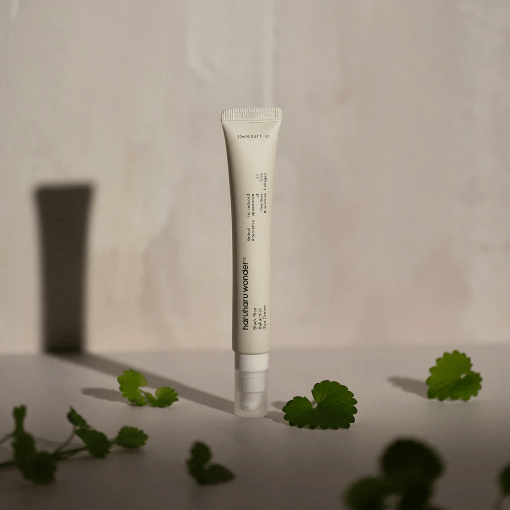 Tuba Haruharu Wonder Black Rice Bakuchiol Eye Cream 20ml obklopená zelenými listami, zameraná na viditeľnosť vrások a jemných liniek.