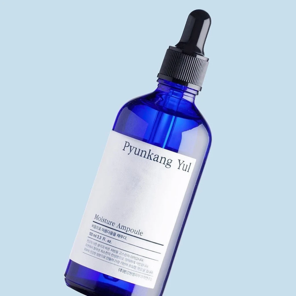 Modrá fľaša na modrom pozadí s Pyunkang Yul's Moisture Ampoule 100ml sérom.