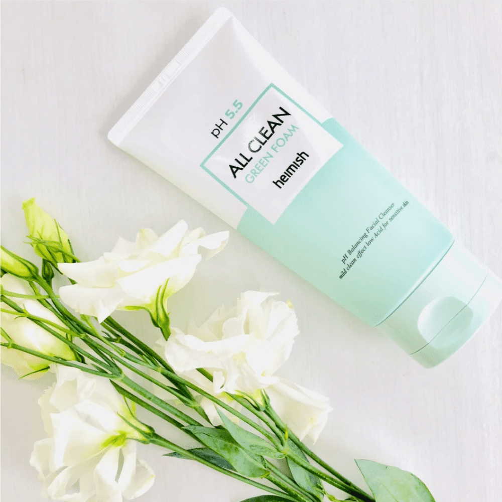 Tuba heimish All Clean Green Foam 150ml vedľa bielych kvetov.